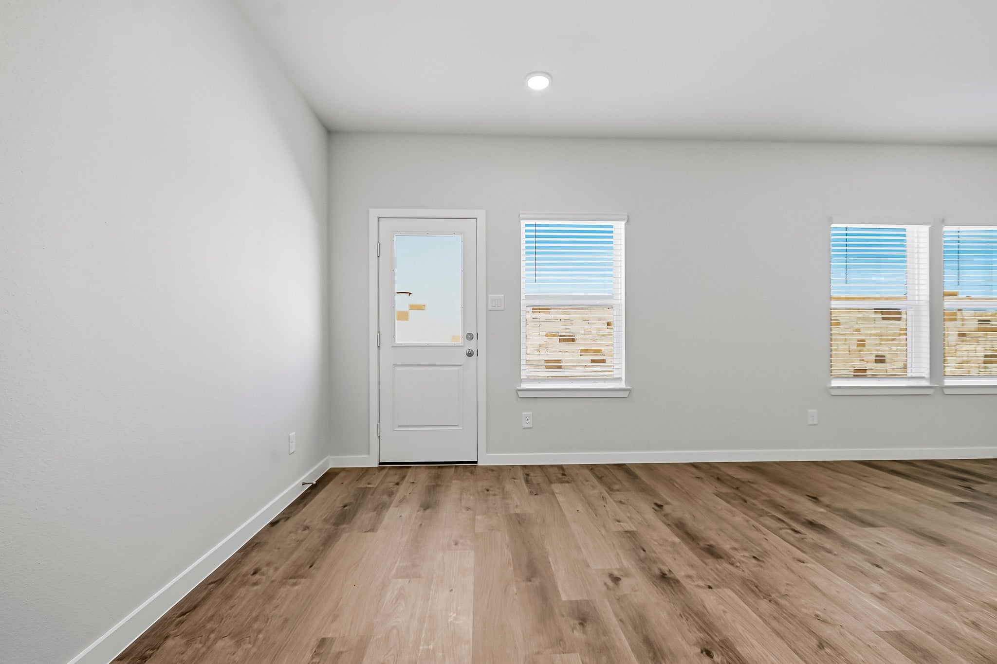 A room with a white door and windows.