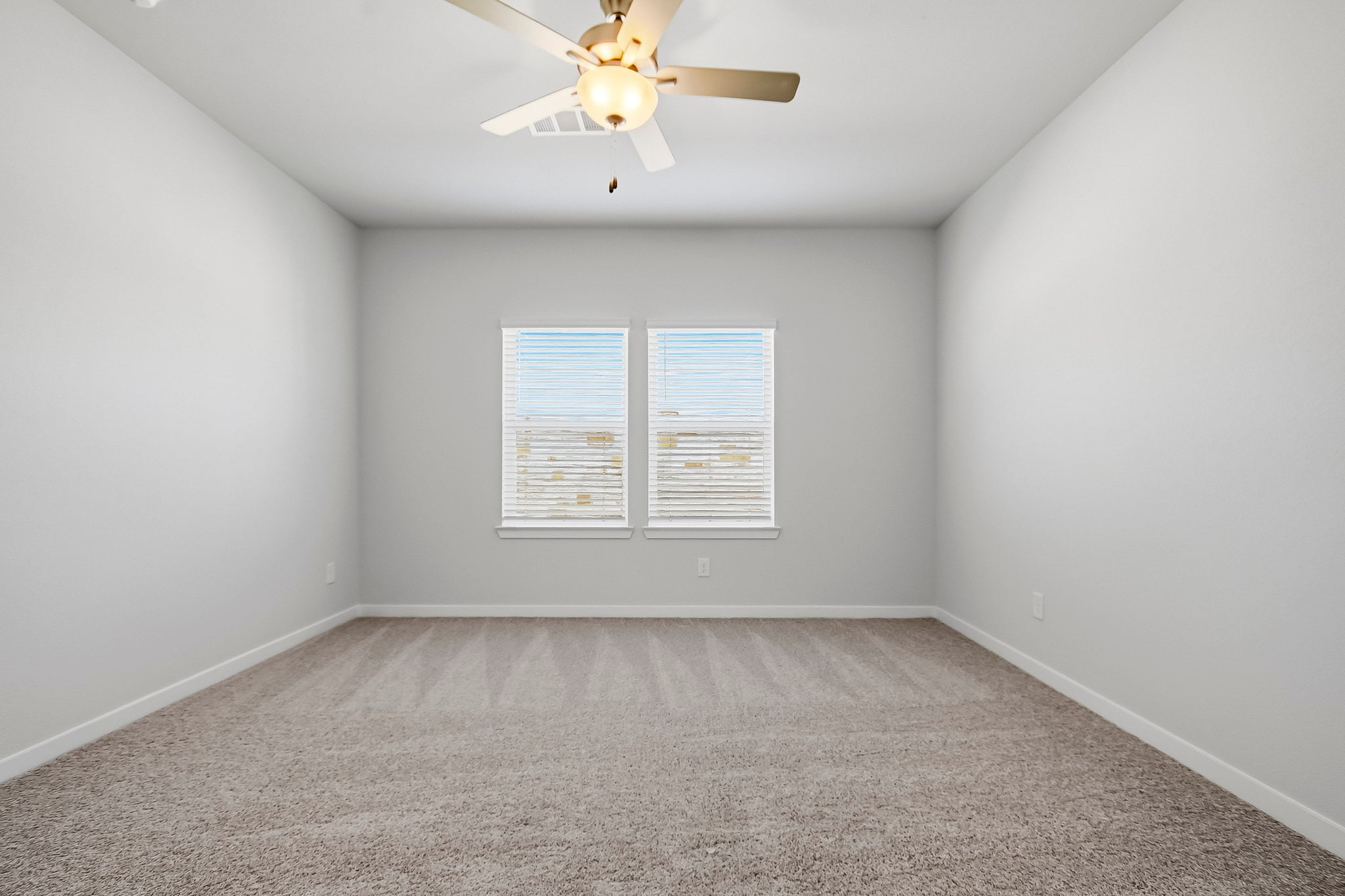 A room with a ceiling fan and a window.
