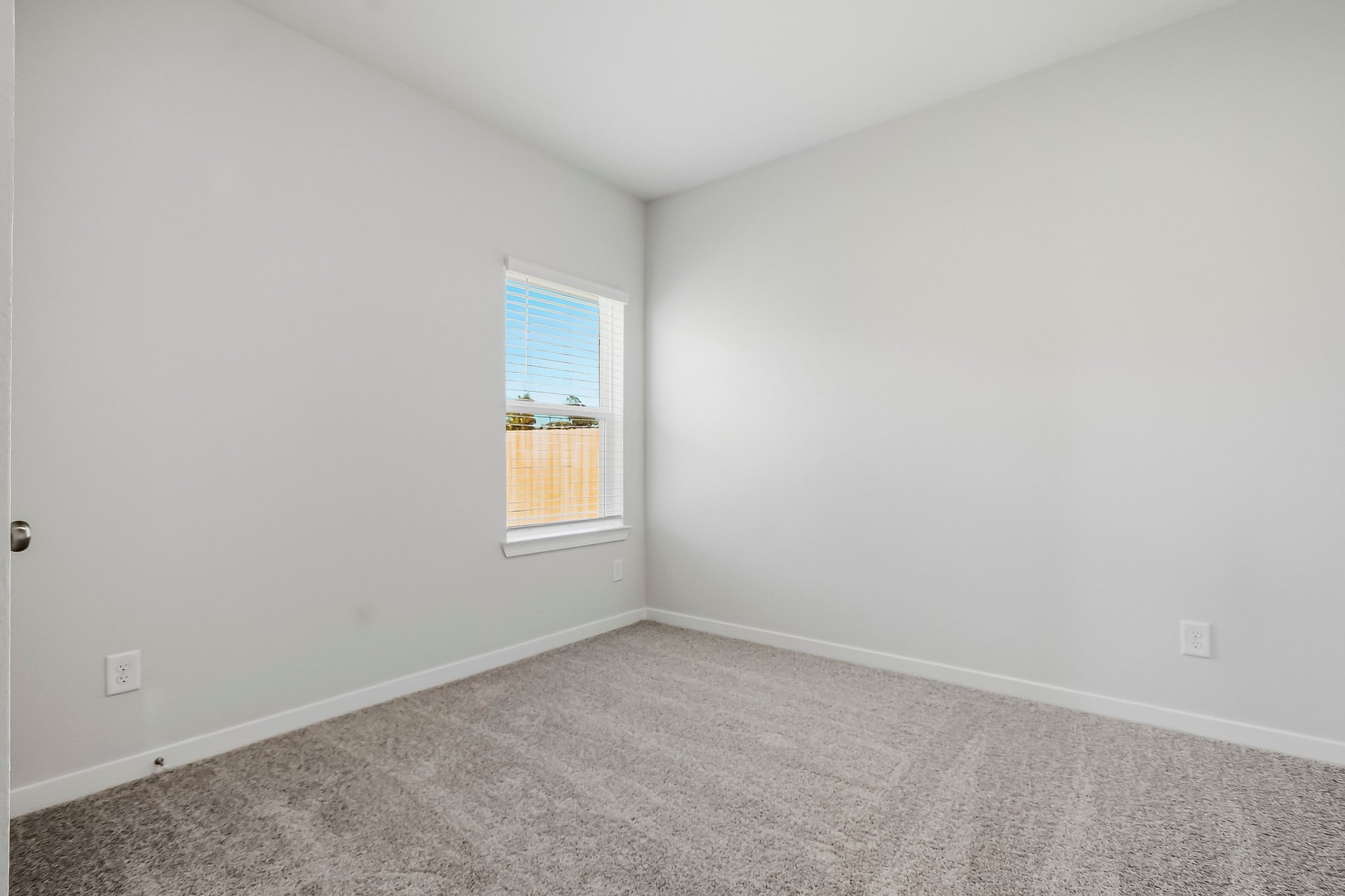 A room with a window and carpet.