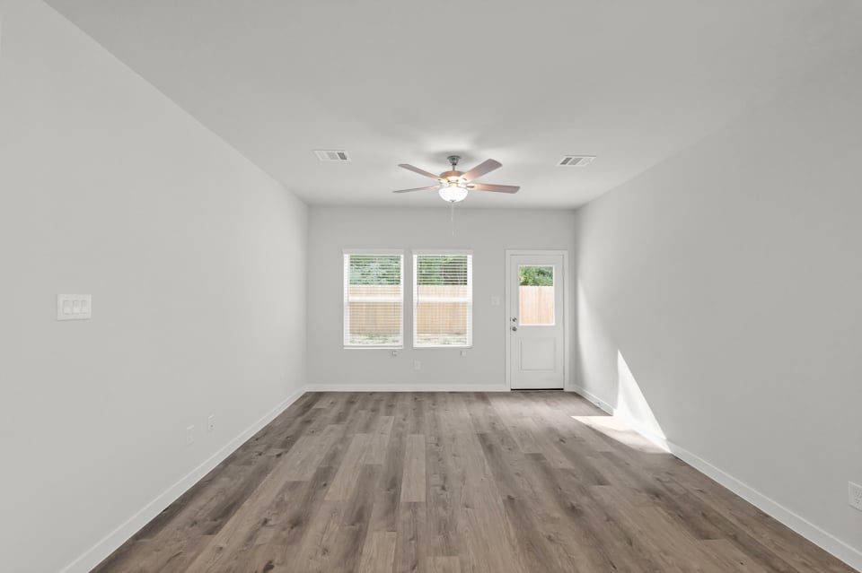 A room with a wood floor and a ceiling fan.