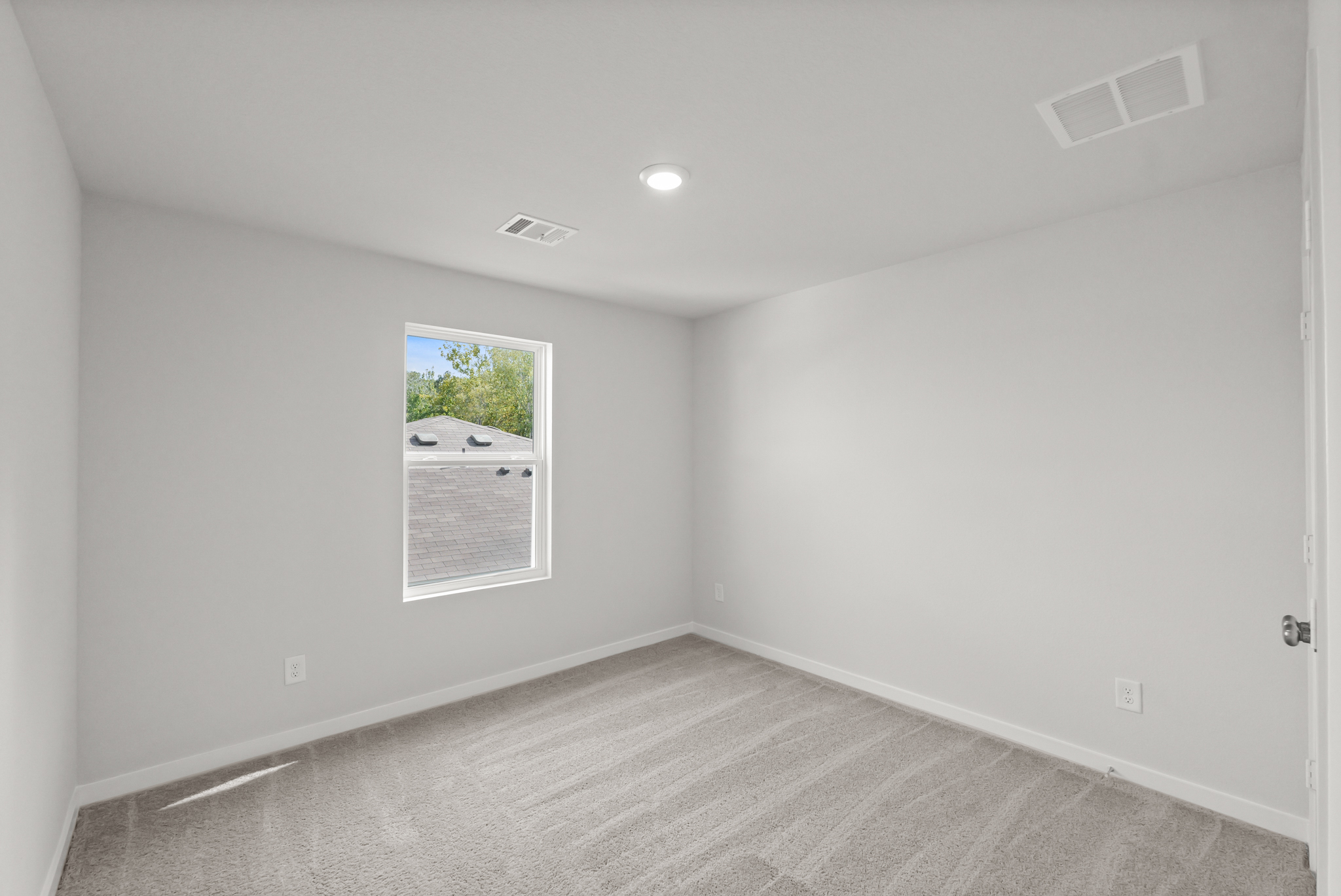 A room with a white wall and a picture on the wall.