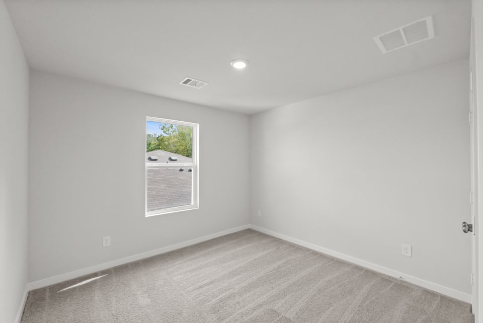 A room with a white wall and a picture on the wall.