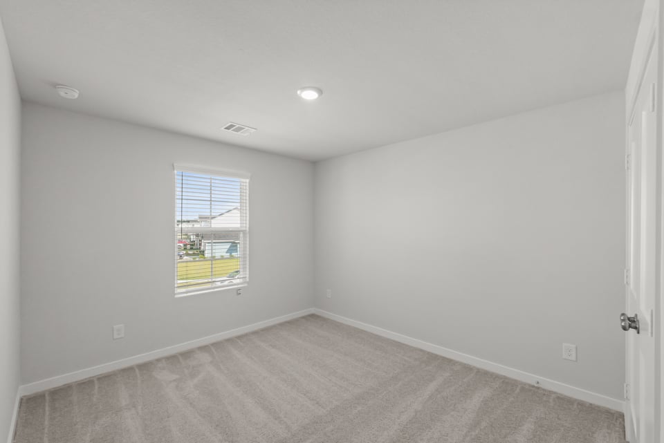 A room with a window and a carpet.