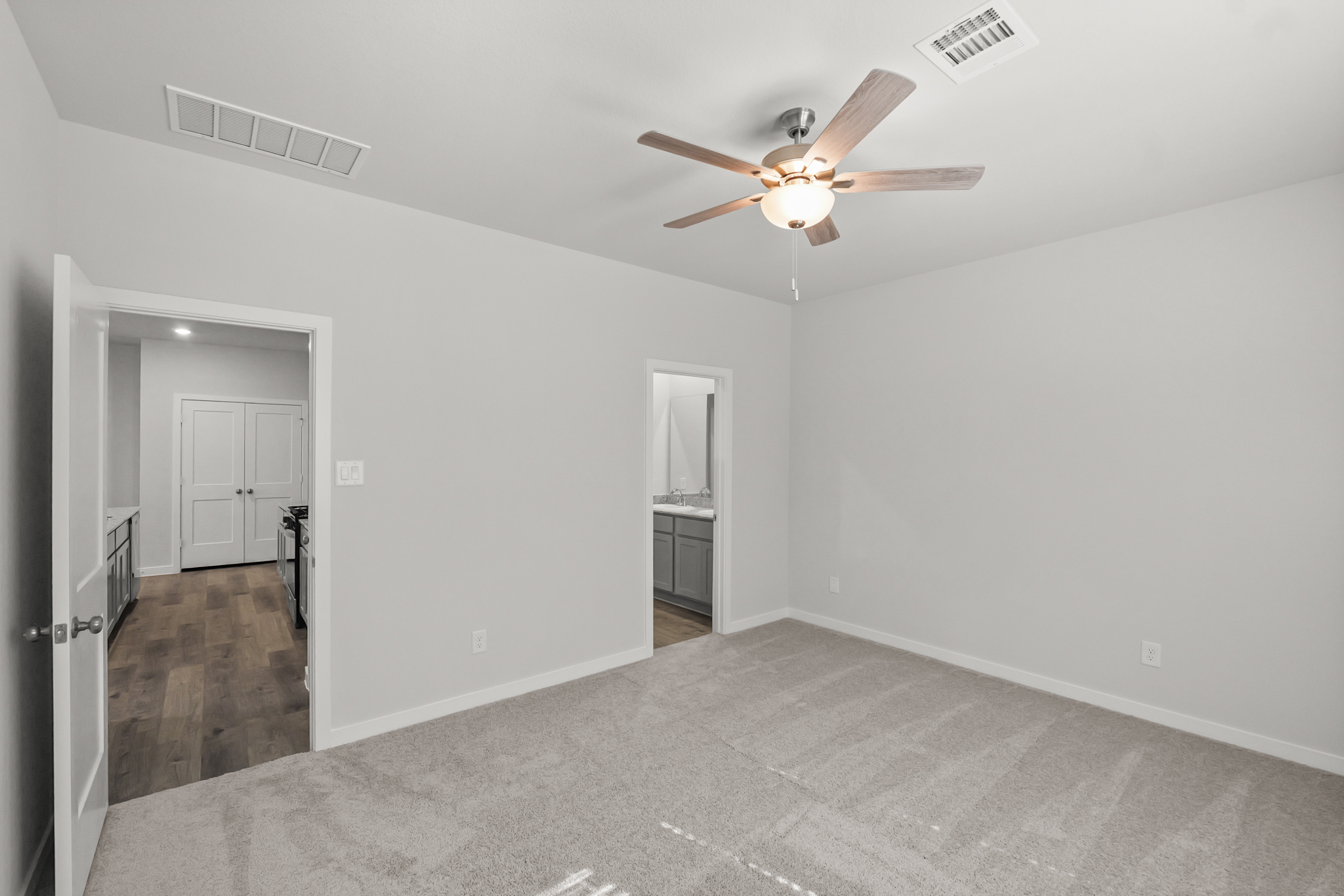 A room with a ceiling fan and a door.