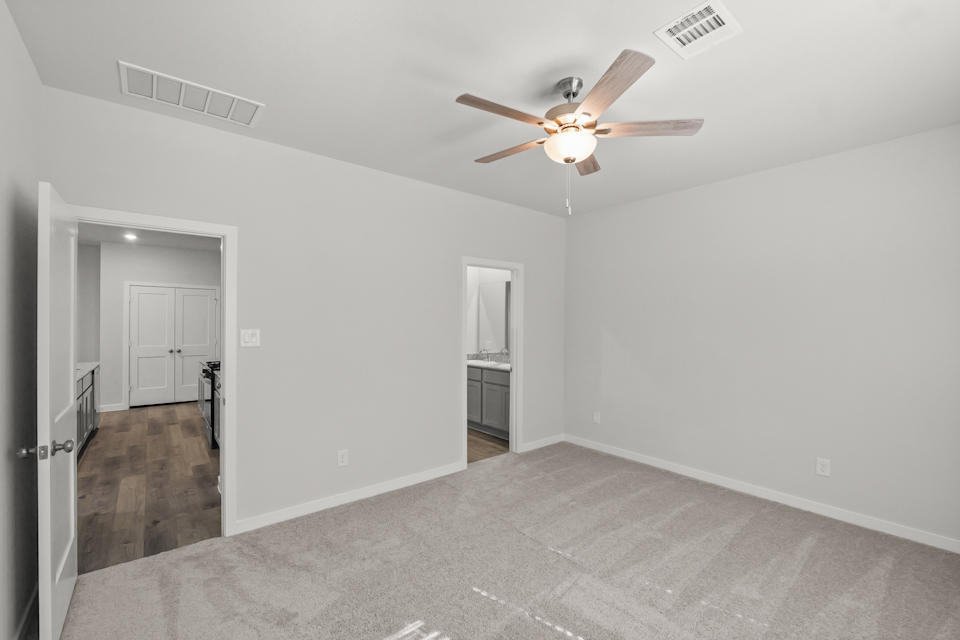 A room with a ceiling fan and a door.