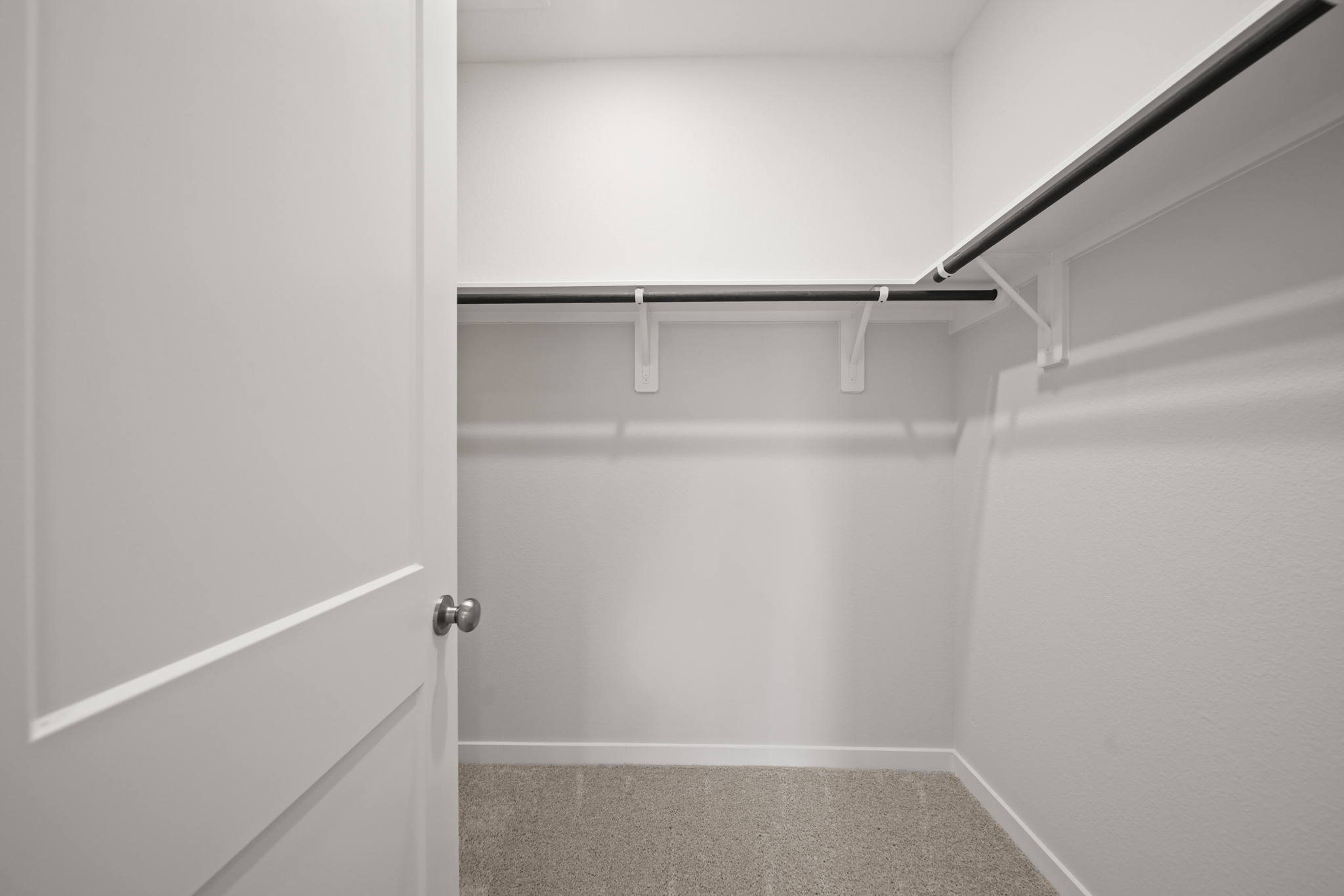 A white door with a metal bar.