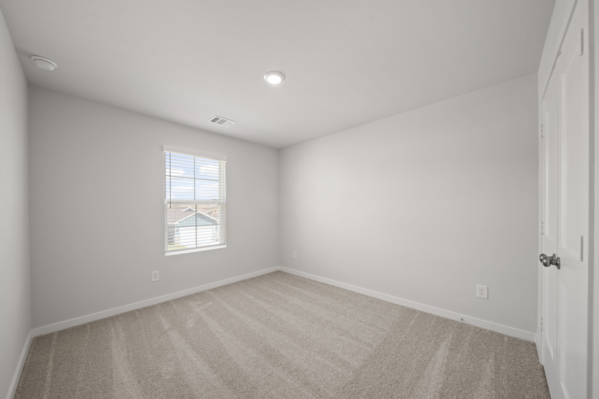 A room with a carpet and a window.