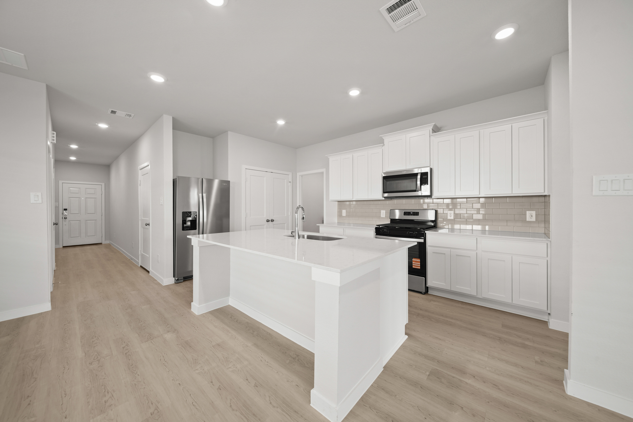 A kitchen with white cabinets.
