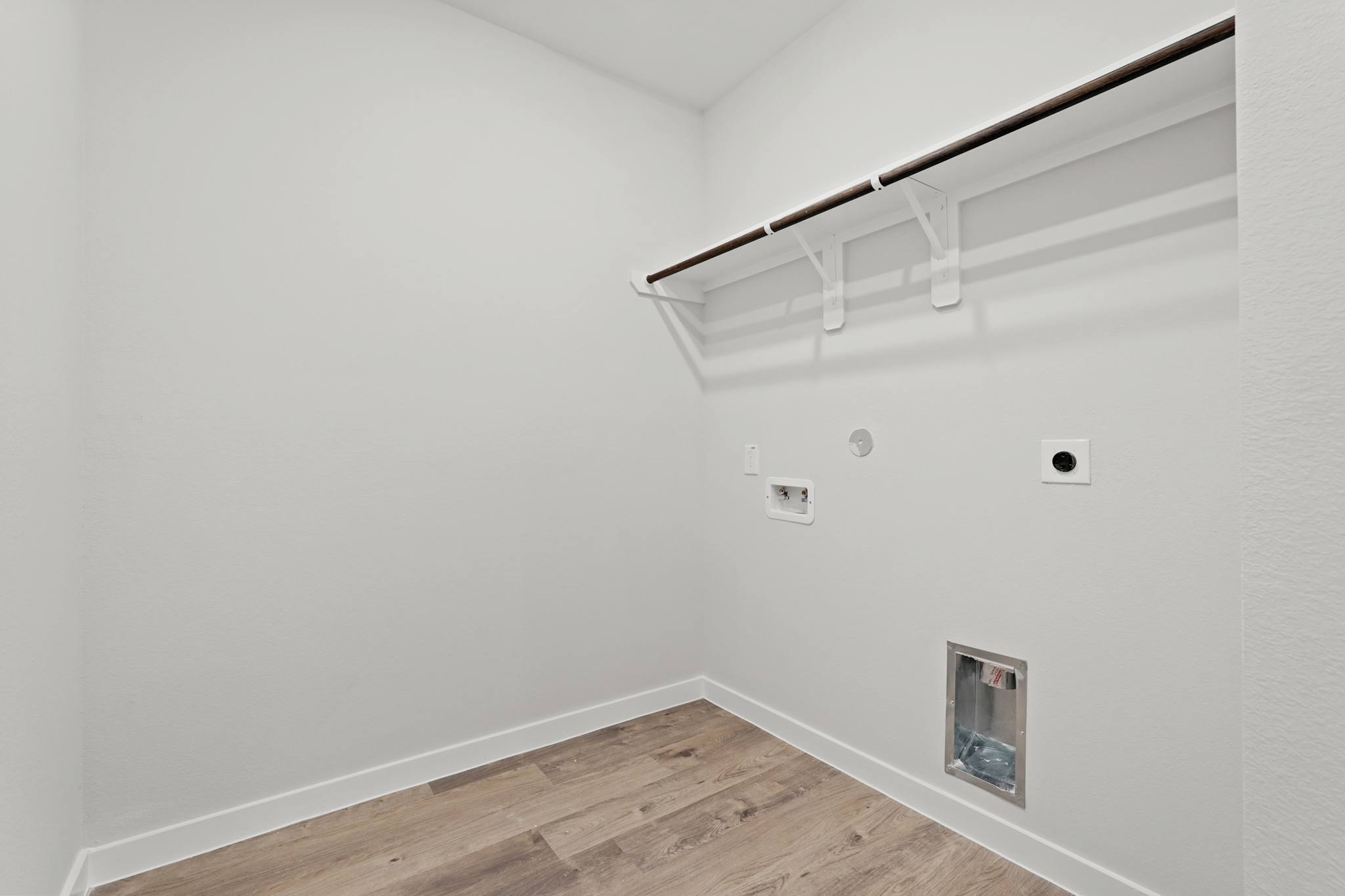 A white room with a wood floor and a wood floor.