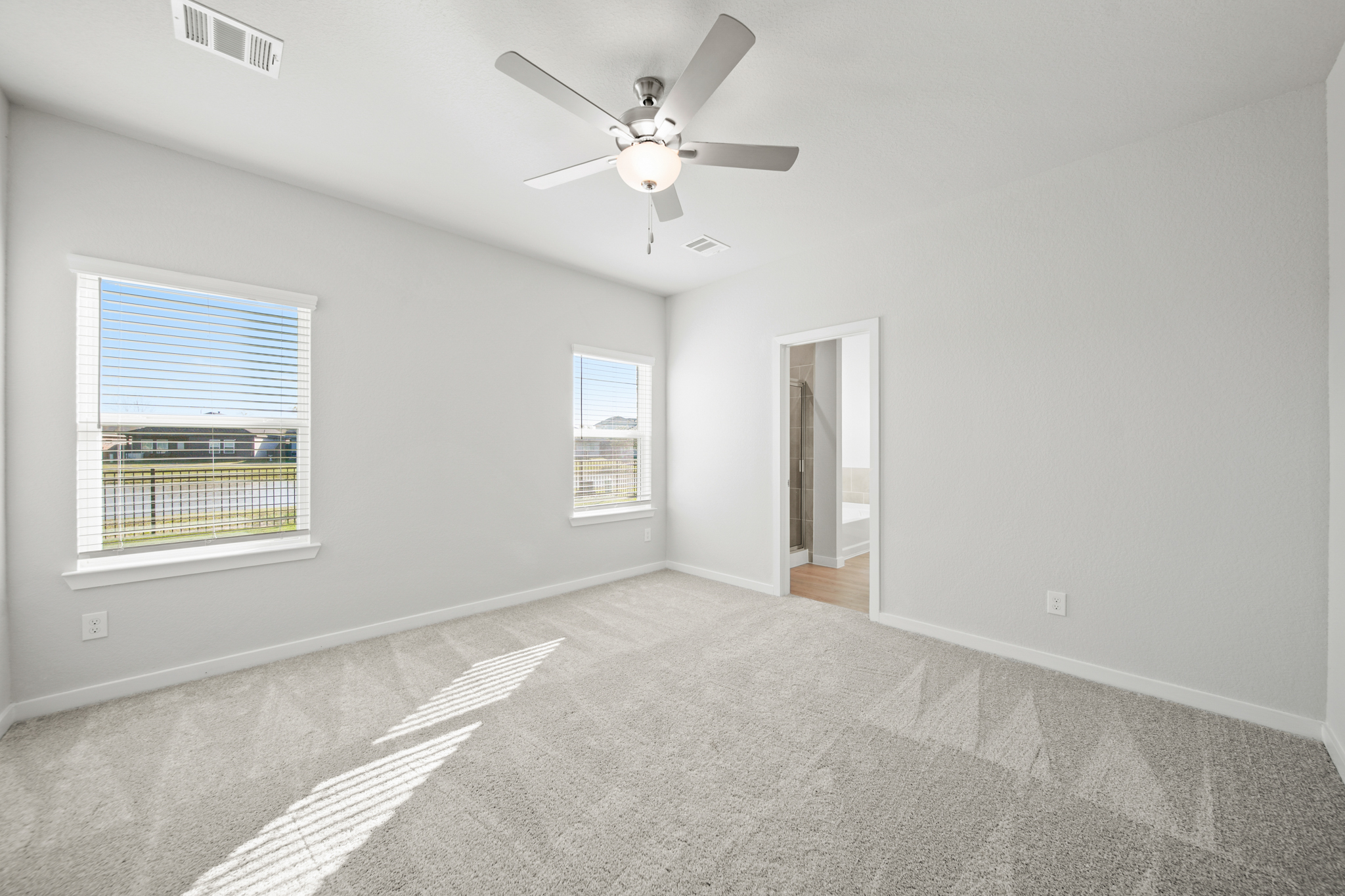 A room with a ceiling fan and a window.