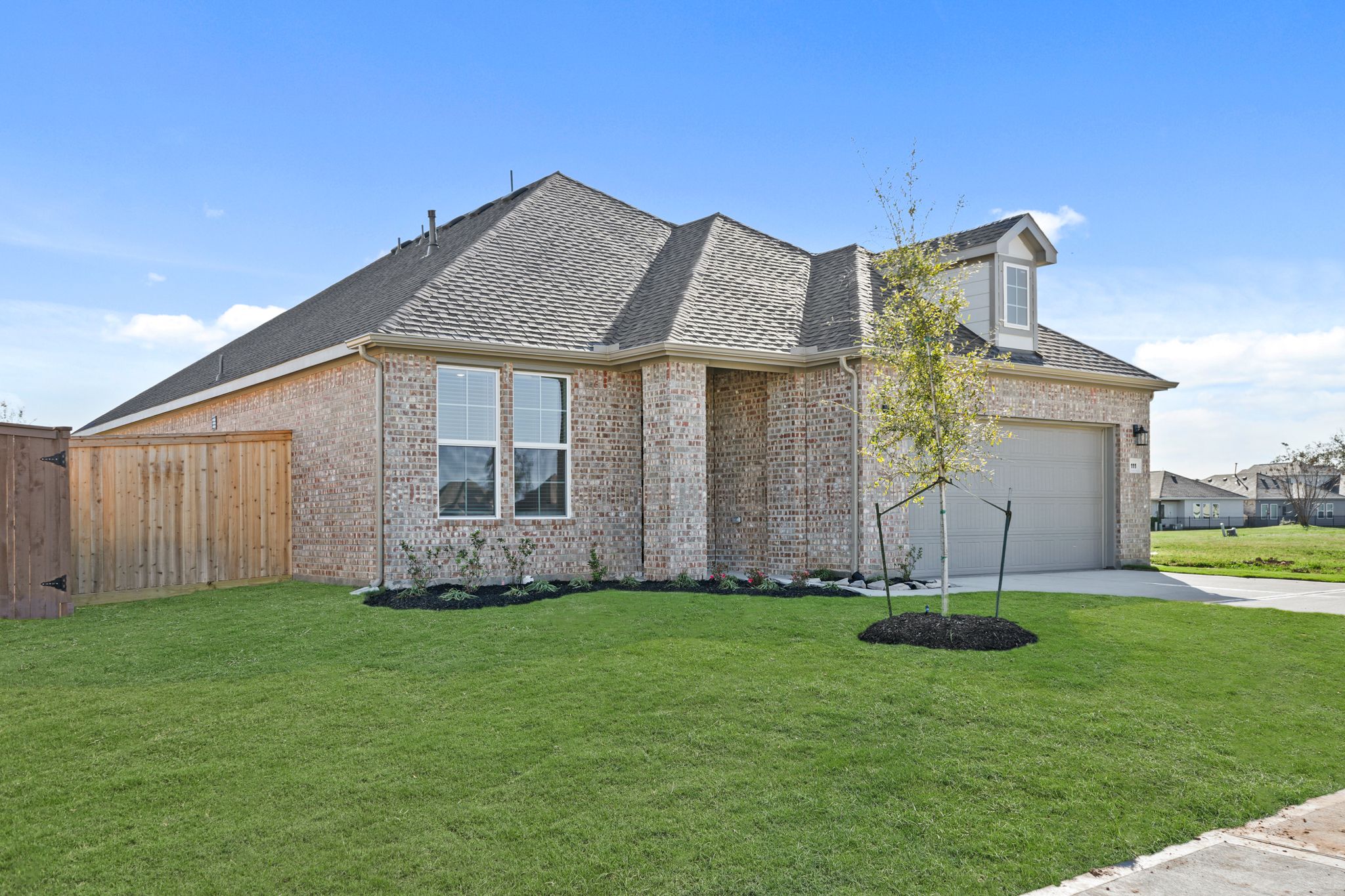 A house with a tree in the front yard.