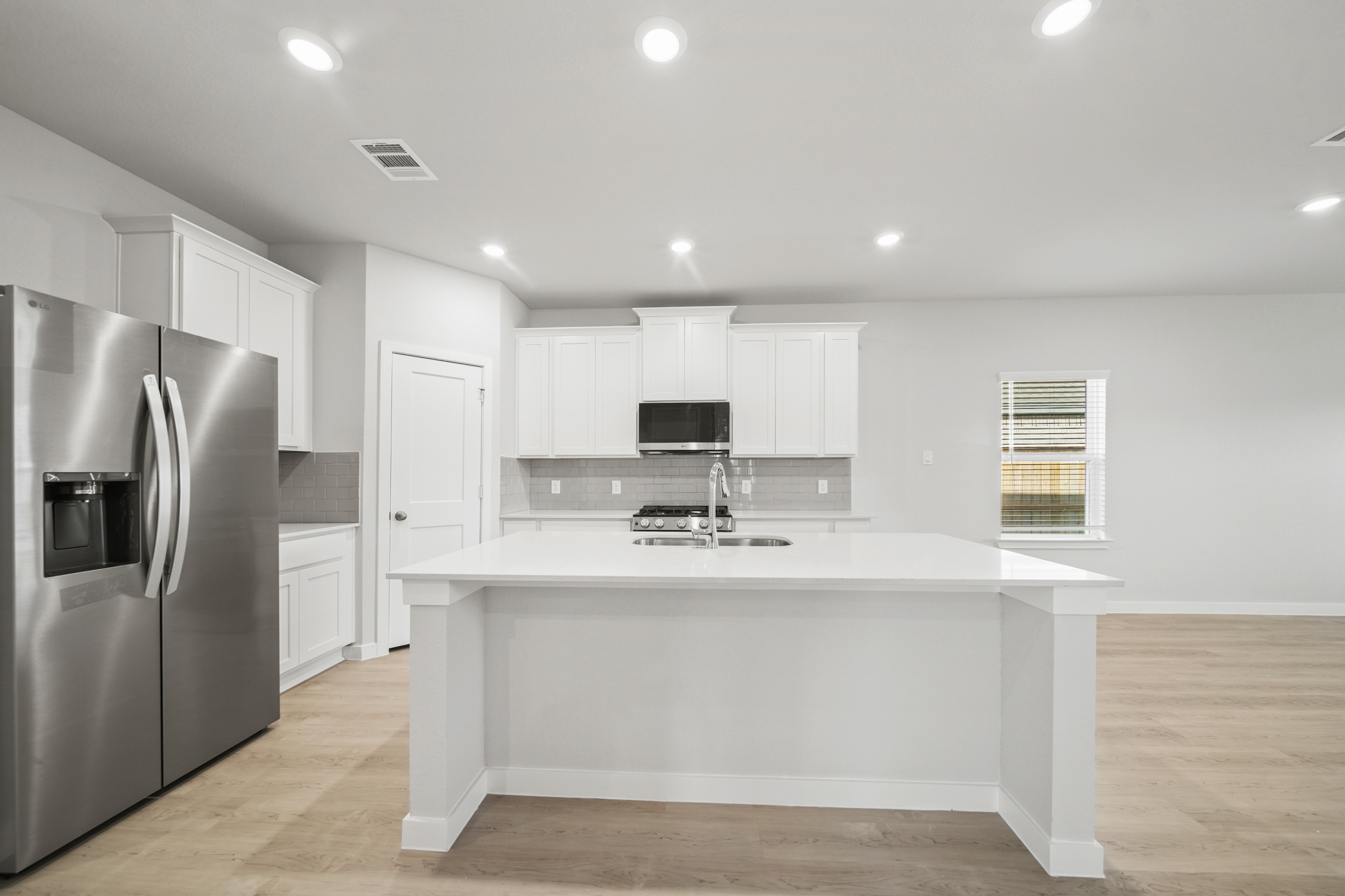 A kitchen with white cabinets.