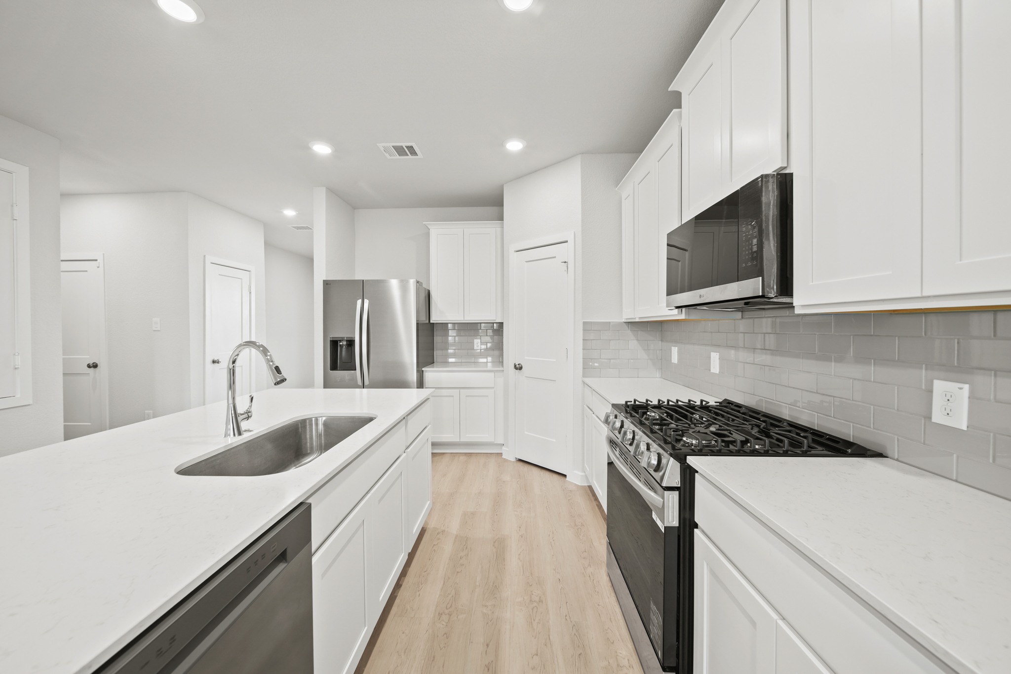 A kitchen with white cabinets.