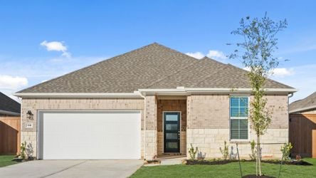 A house with a garage and a tree in the front.