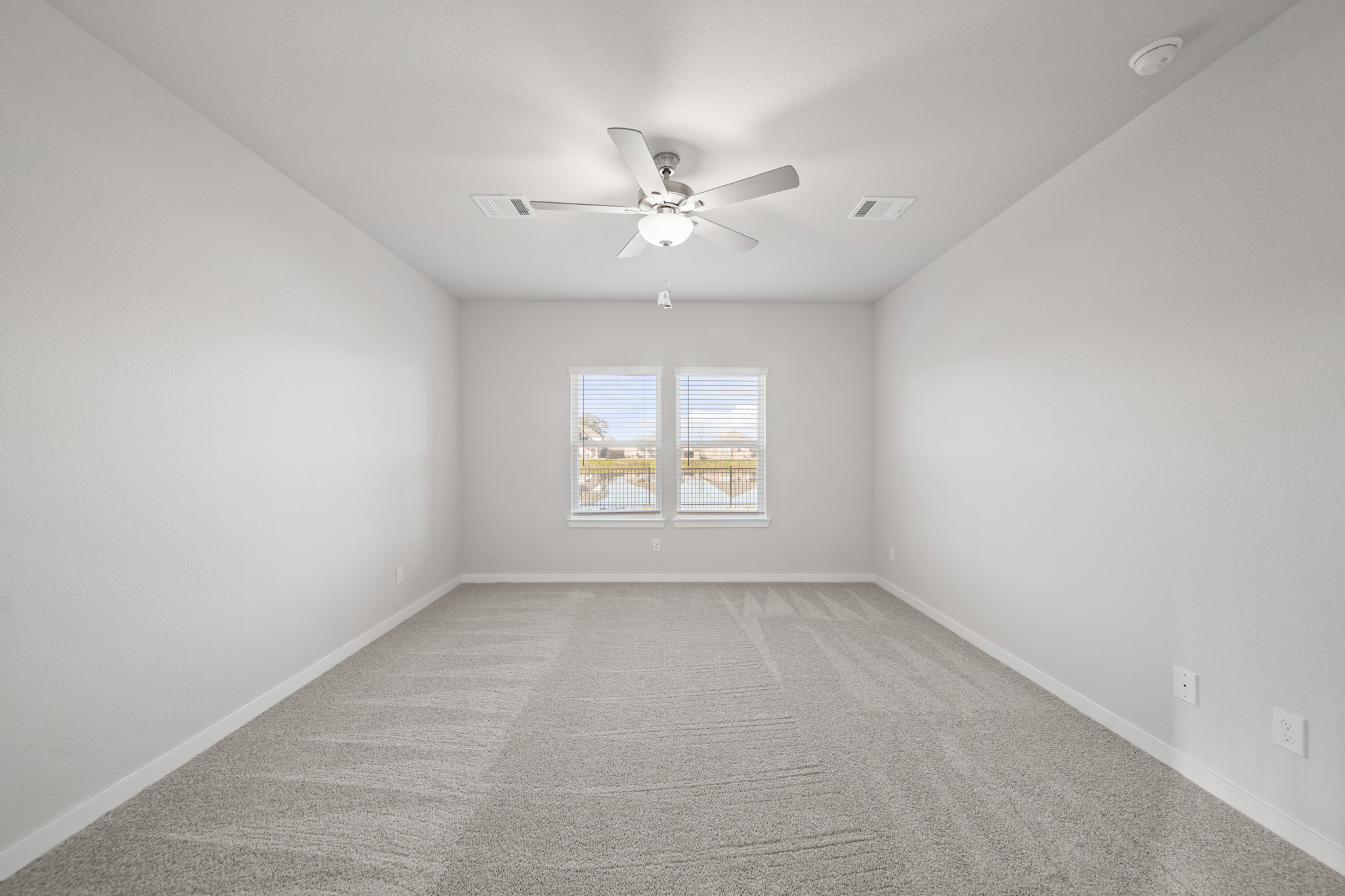 A room with a ceiling fan and a window.