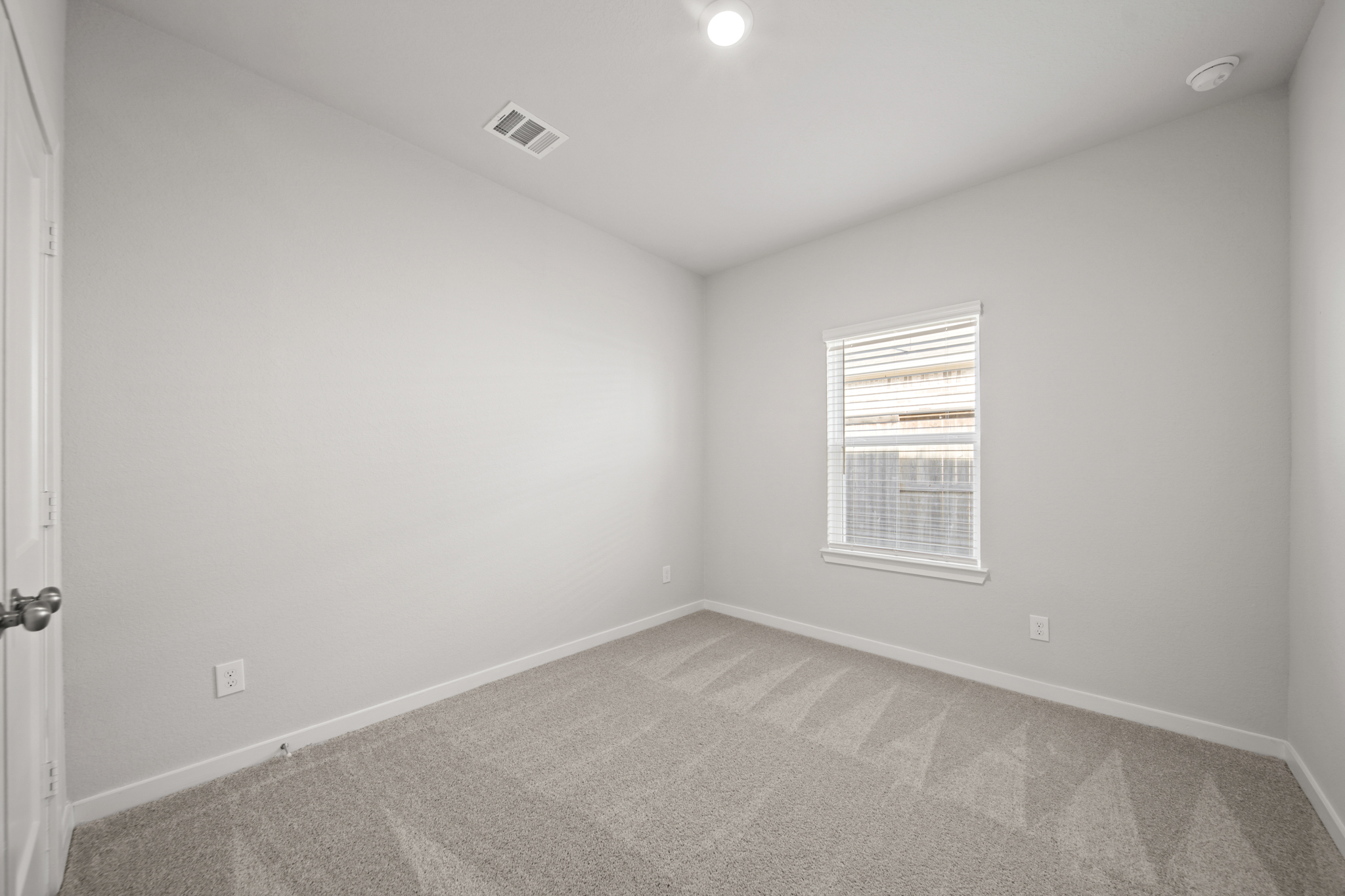 A room with a carpet and a window.