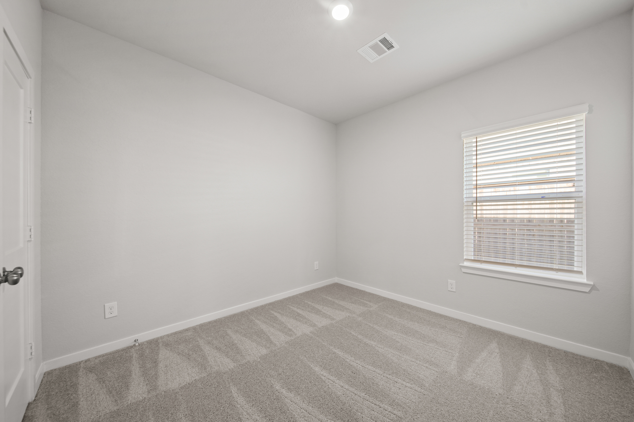 A room with a carpet and a window.