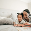 momd and daughter read in bed istock-954012234