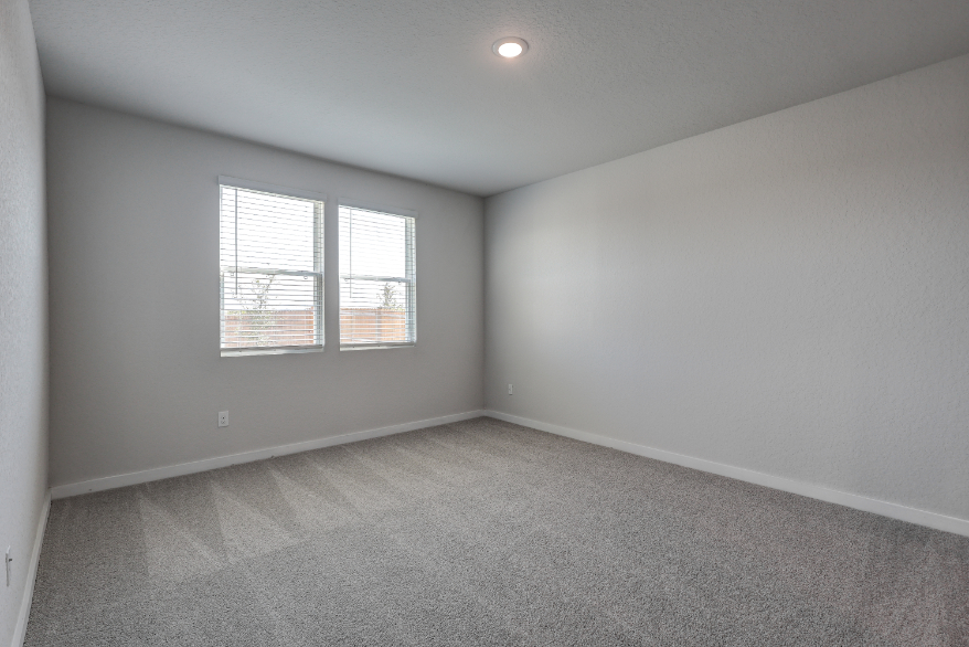 A room with a window and a carpet.