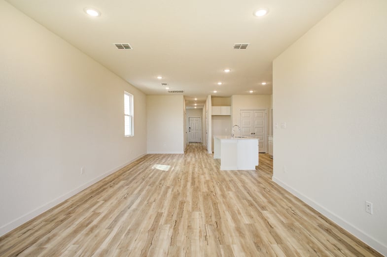 A room with white walls and wood floors.