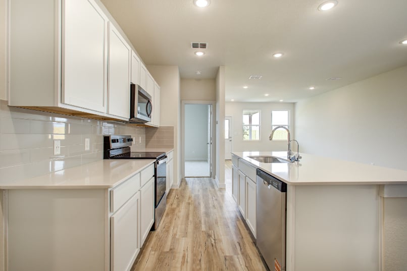 A kitchen with white cabinets.