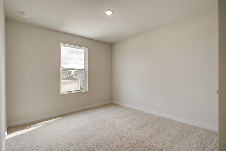 A room with a window and carpet.