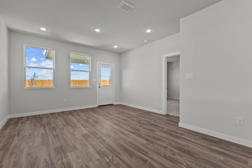 A room with a wood floor and white walls.