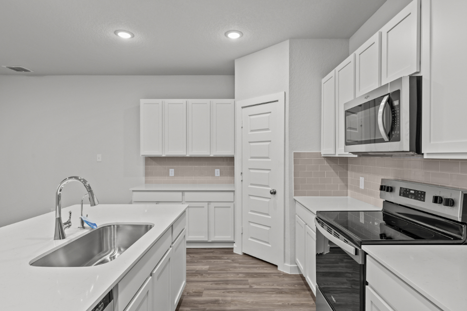 A kitchen with white cabinets.