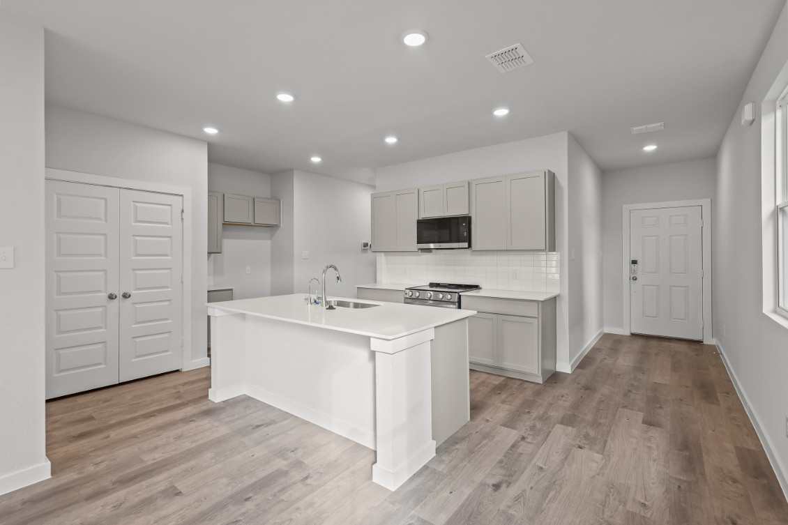 A kitchen with white cabinets.