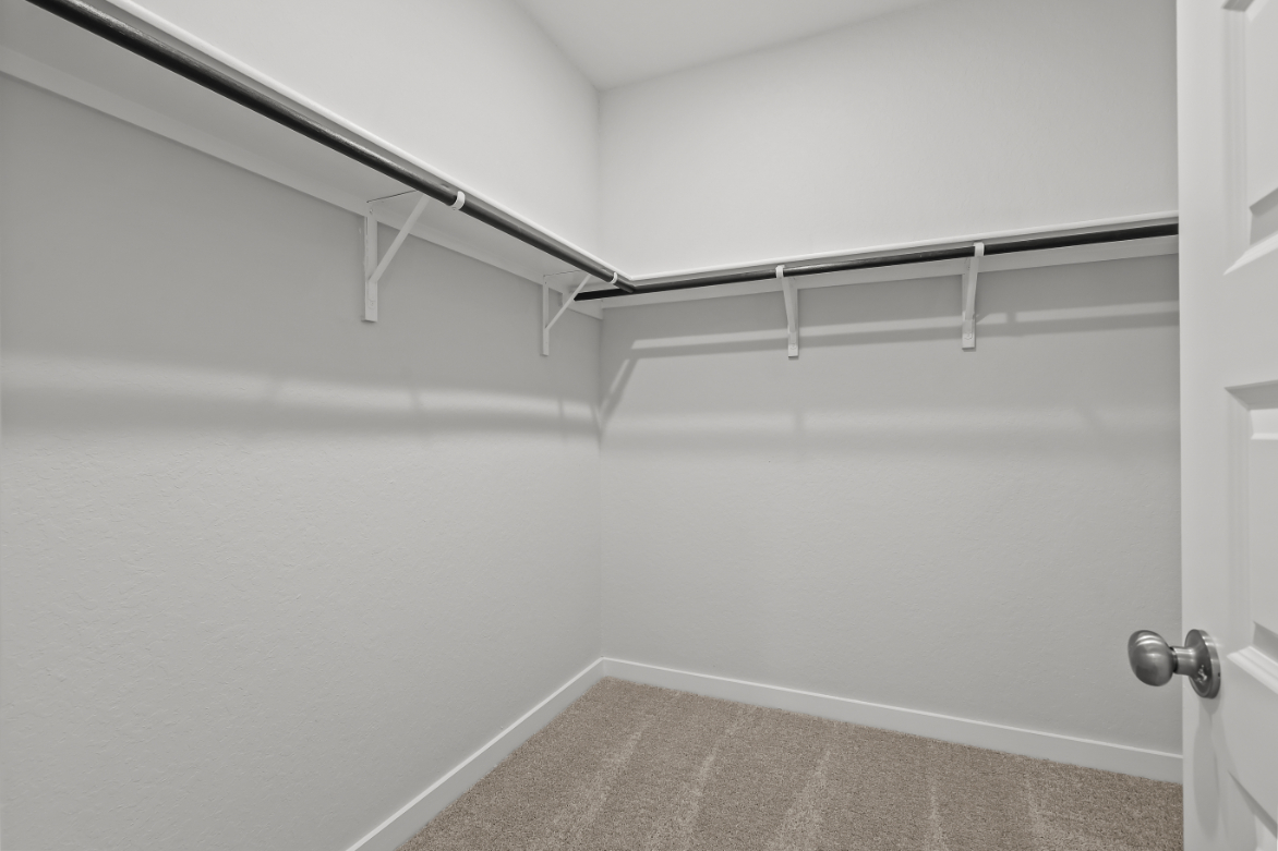 A white wall with a metal bar.