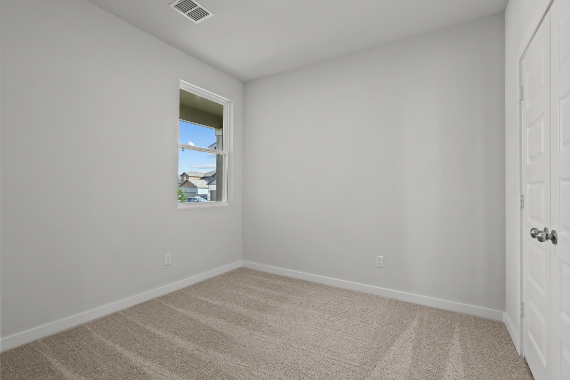 A room with a window and a carpet.