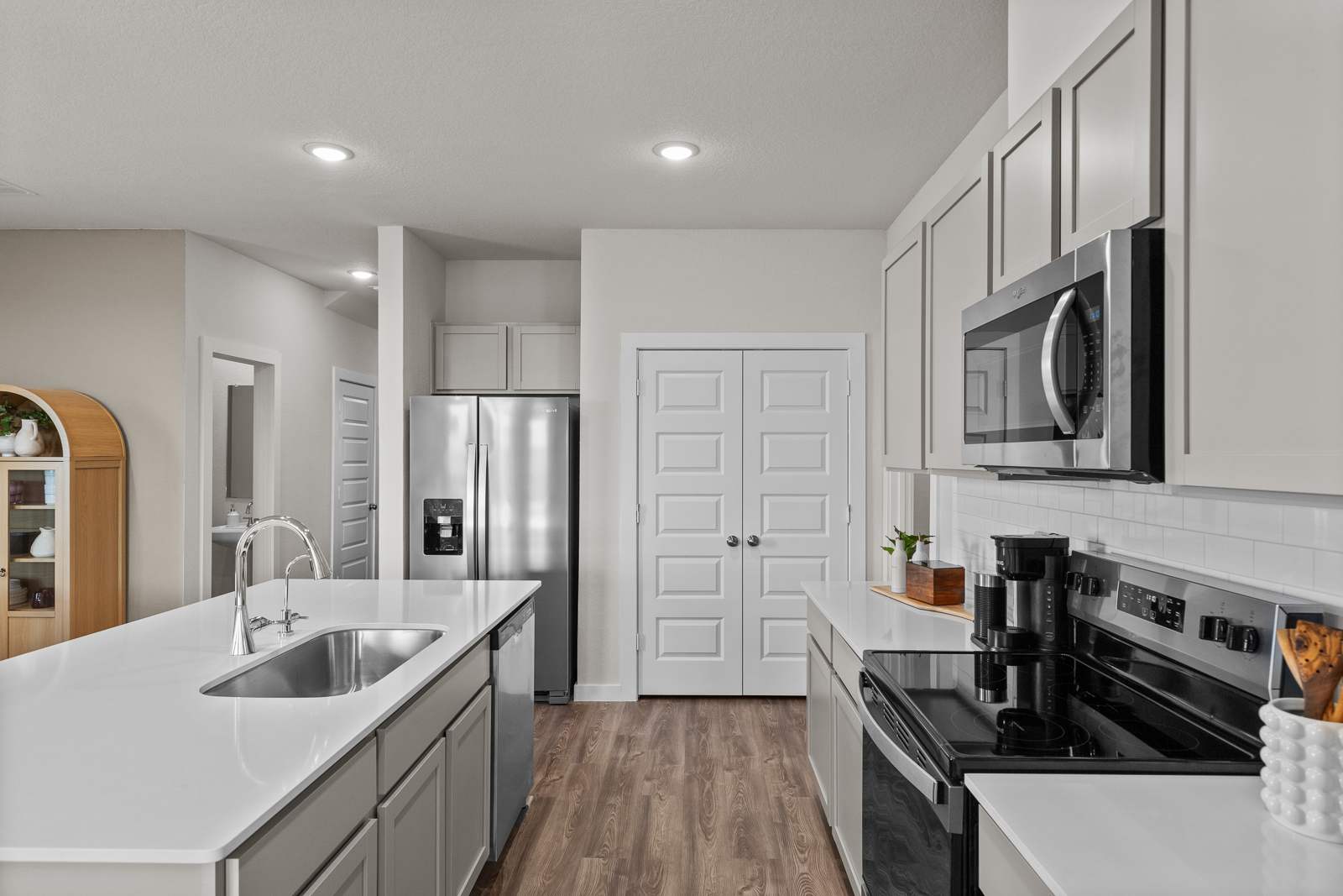 A kitchen with white cabinets.