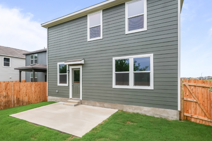 A grey house with a fence.