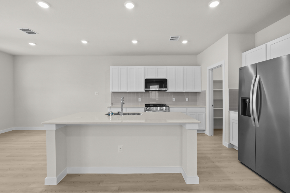 A kitchen with white cabinets.