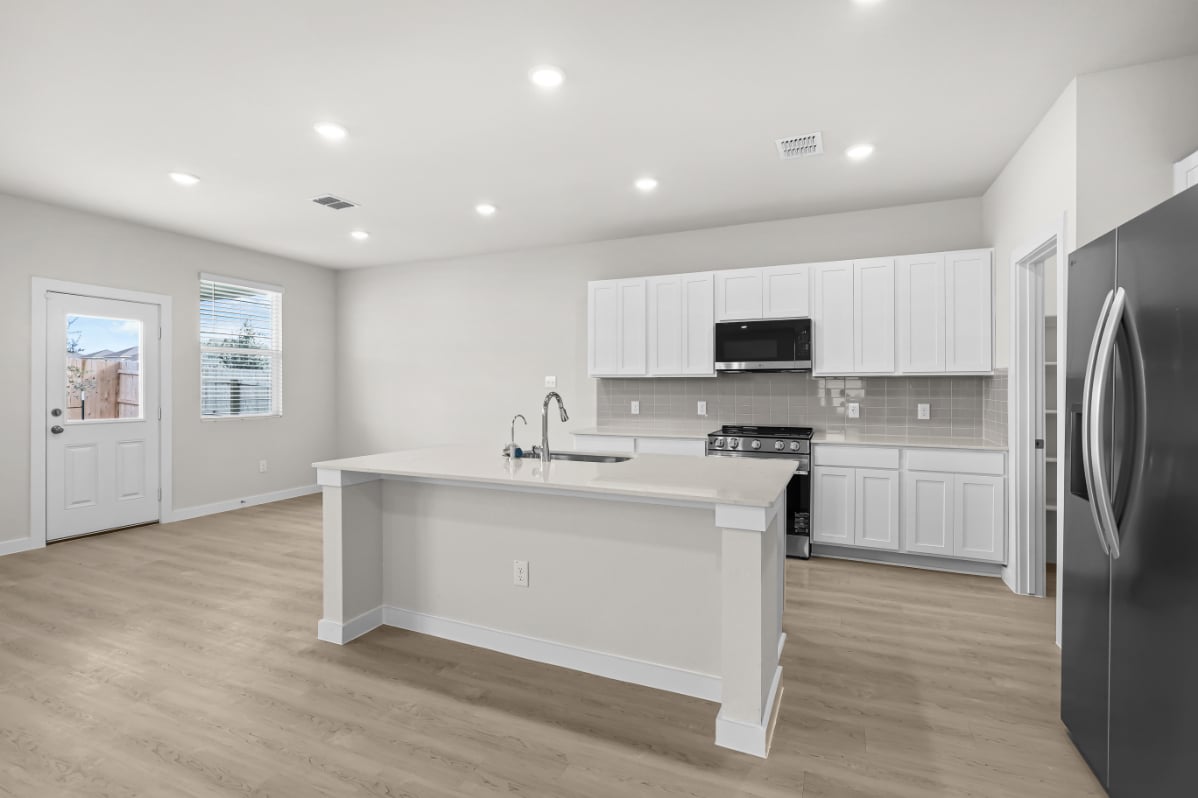 A kitchen with white cabinets.