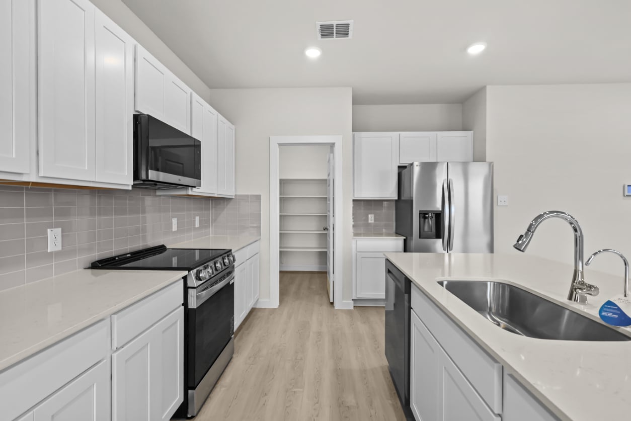 A kitchen with white cabinets.