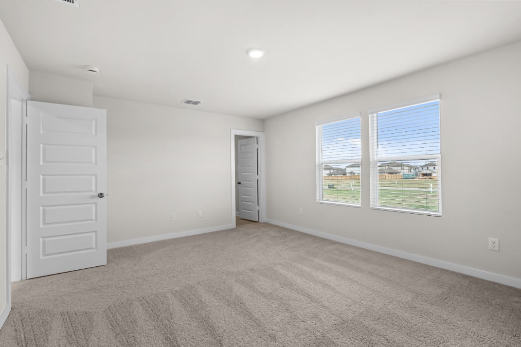 A room with a carpet and windows.