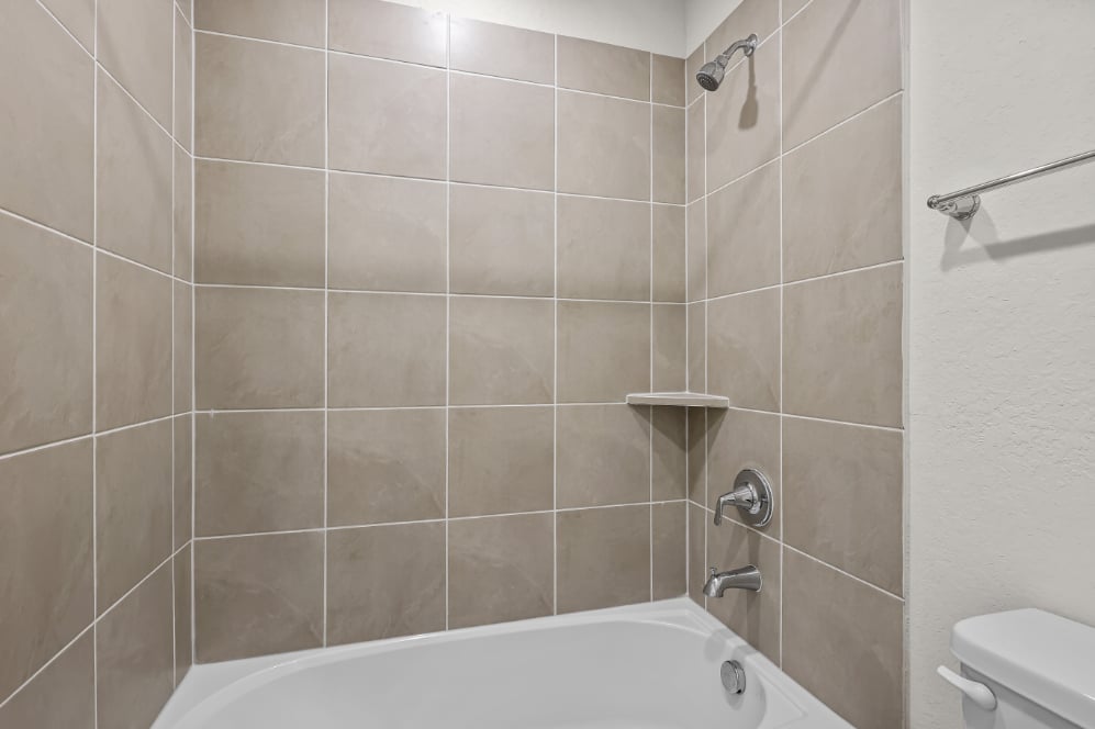 A bathroom with a bathtub and toilet.
