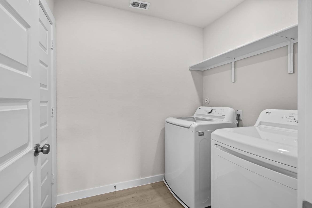 A room with white cabinets and a washing machine.