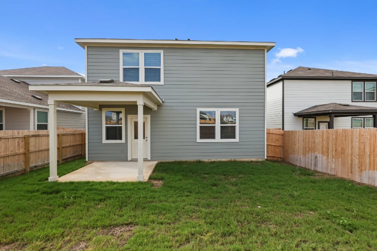 A house with a fence and grass.