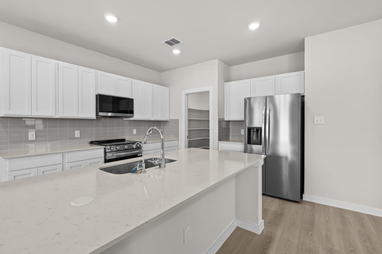 A kitchen with white cabinets.