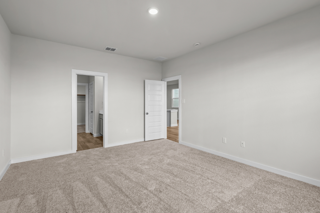 A room with a carpet and a door.