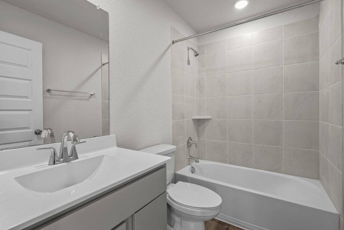 A bathroom with a tub sink and toilet.