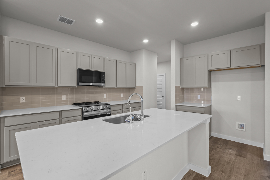 A kitchen with white cabinets.