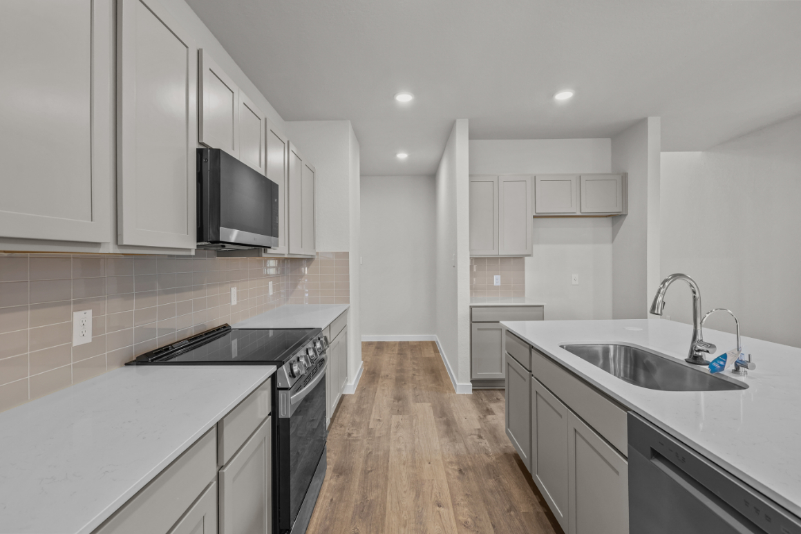 A kitchen with white cabinets.