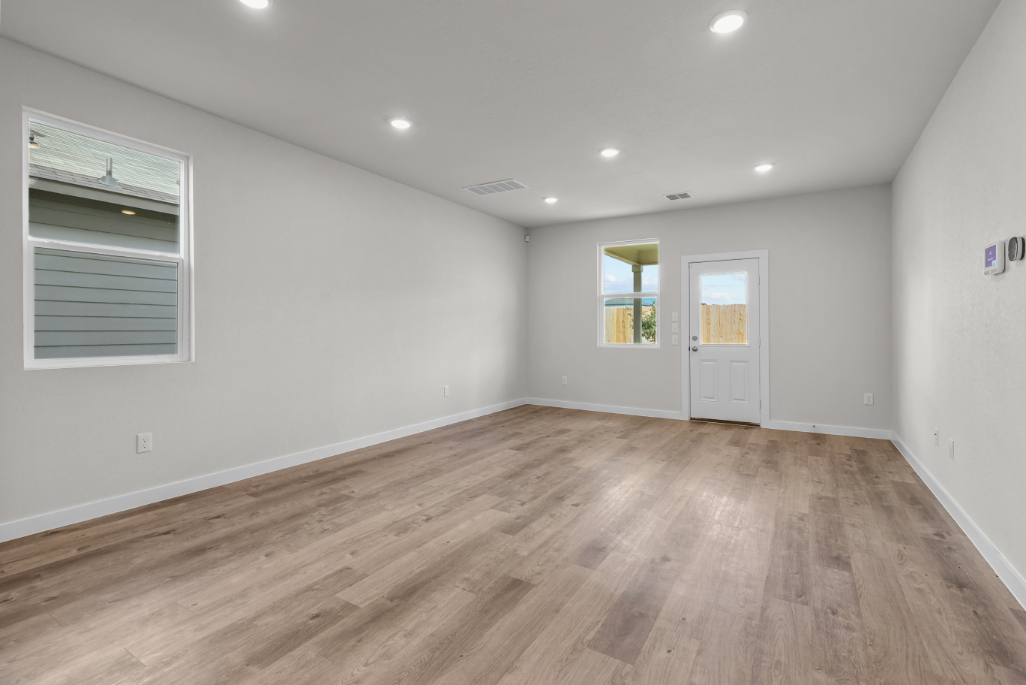 A room with a wood floor and white walls.