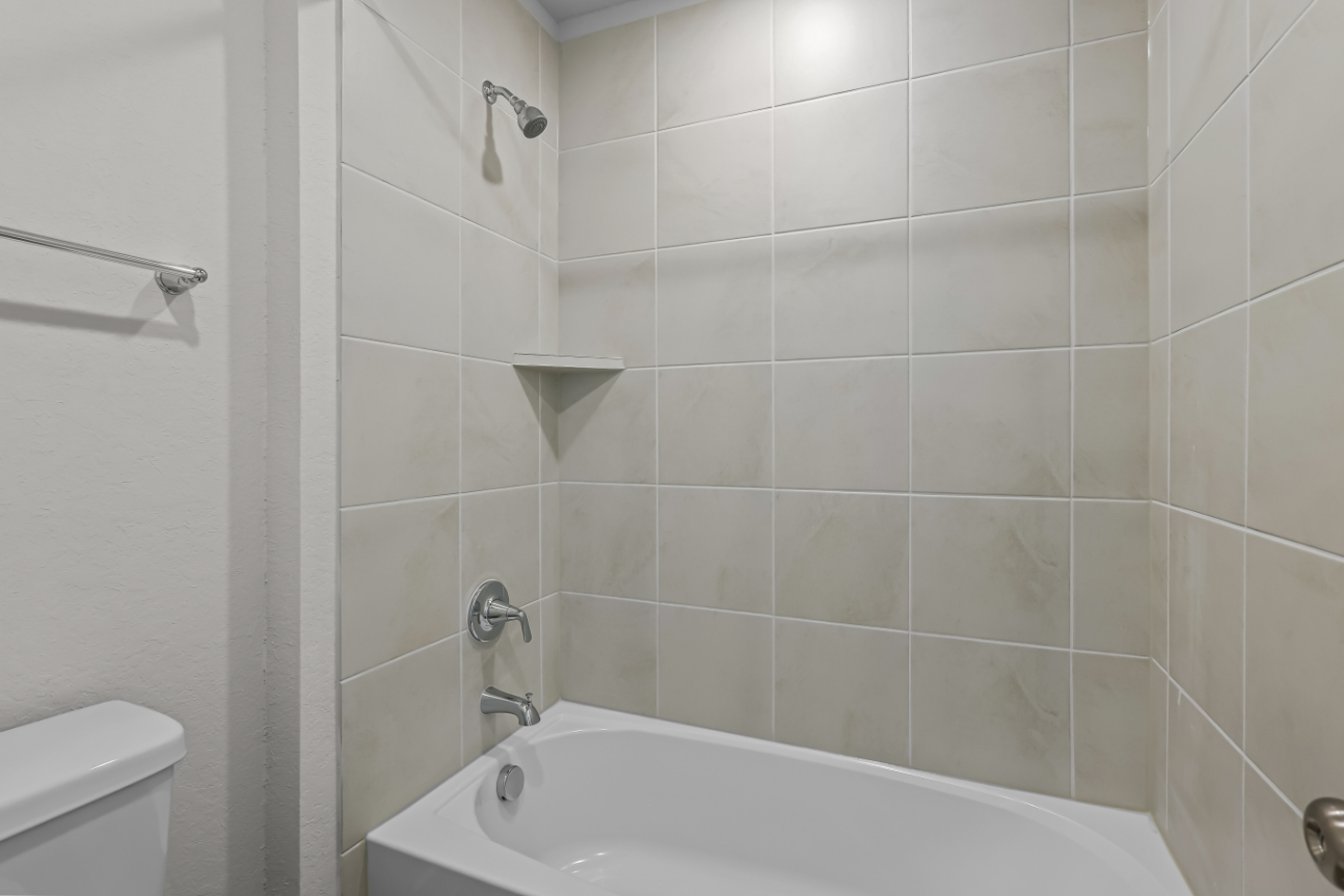 A bathroom with a bathtub and toilet.