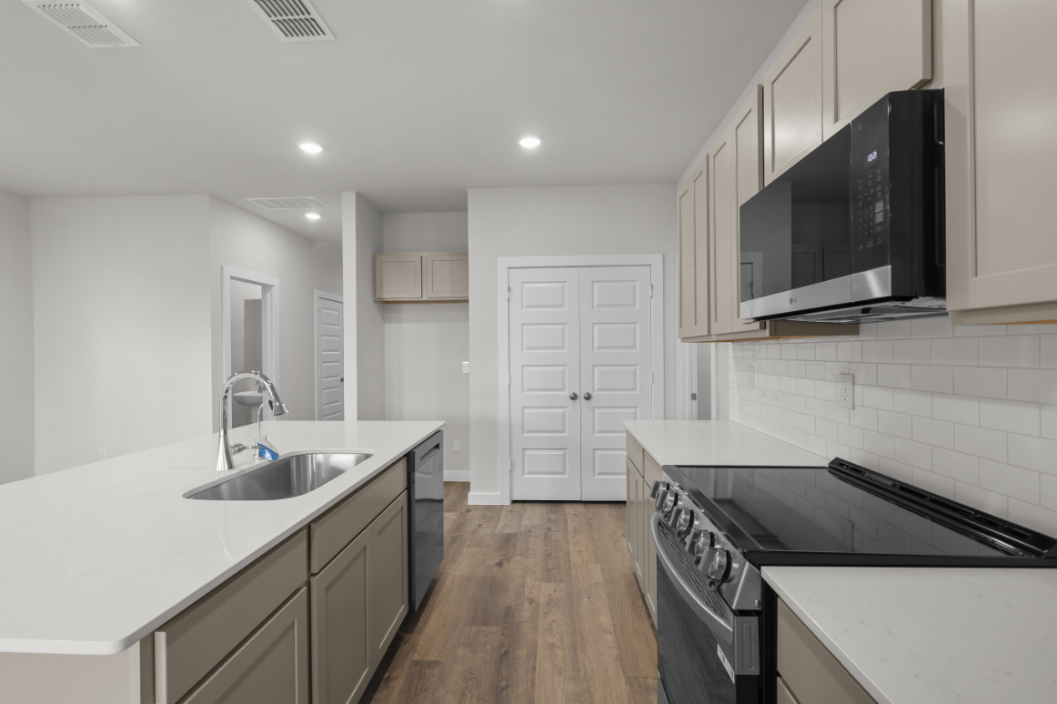 A kitchen with white cabinets.