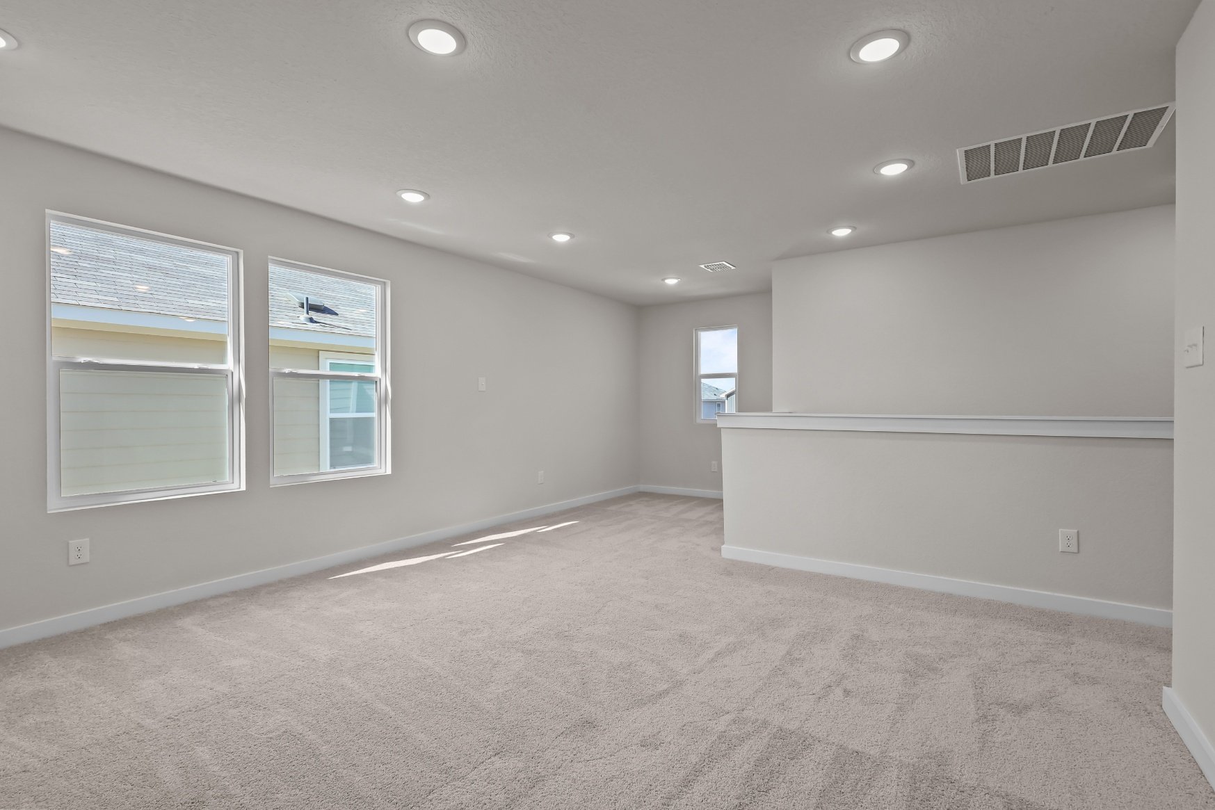 A room with a carpet and windows.