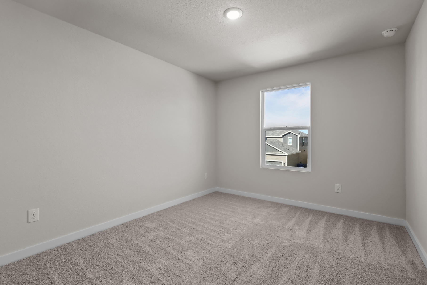 A room with a window and carpet.